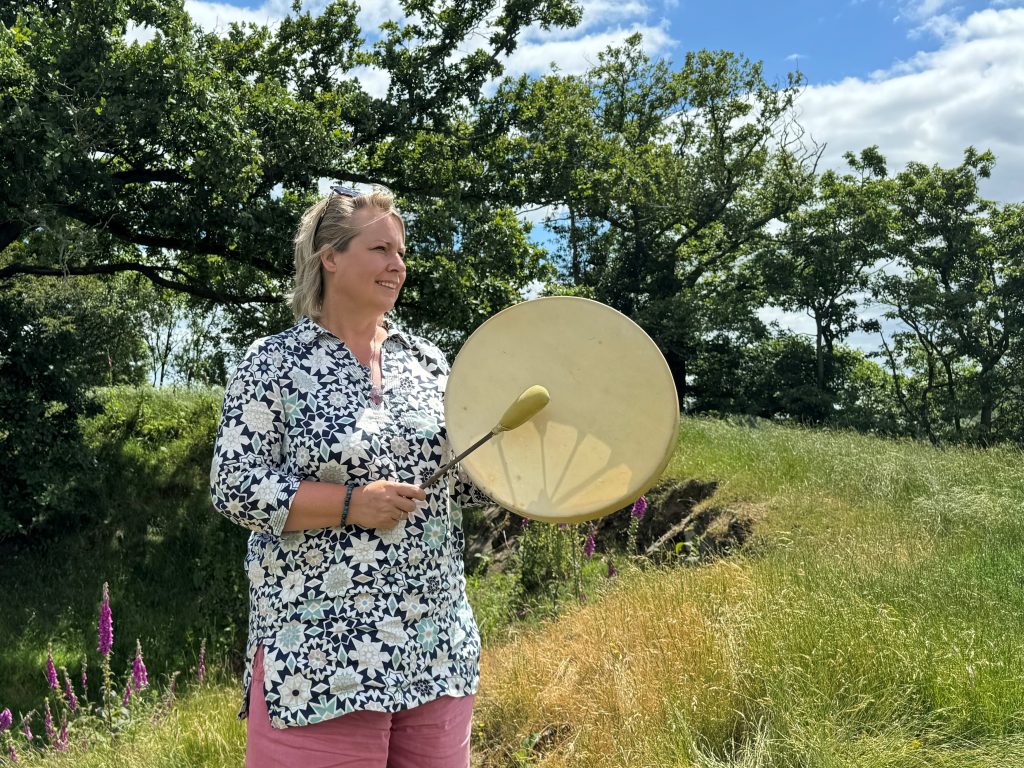 Rev. Helen James drumming at the site of the Whiteleaved Oak near the Malvern Hills in Worcestershire, UK