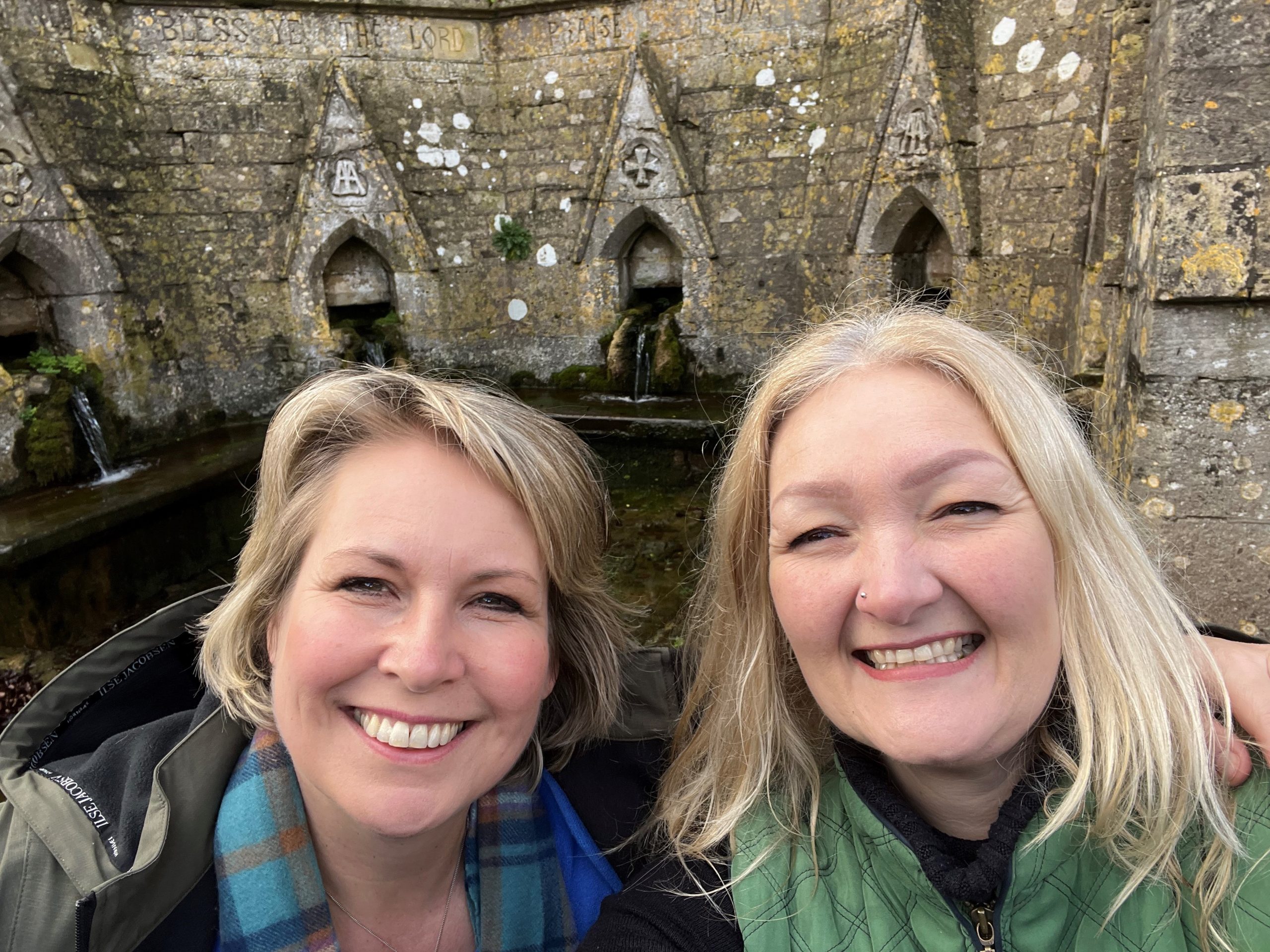 Rev Helen James and Kelly Peacey are smiling infront of the Seven Wells at Bisley