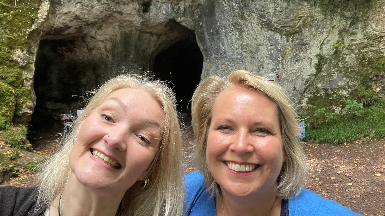 Kelly Peacey and Rev. Helen James smiling at King Arthur's Cave in Herefordshire, UK